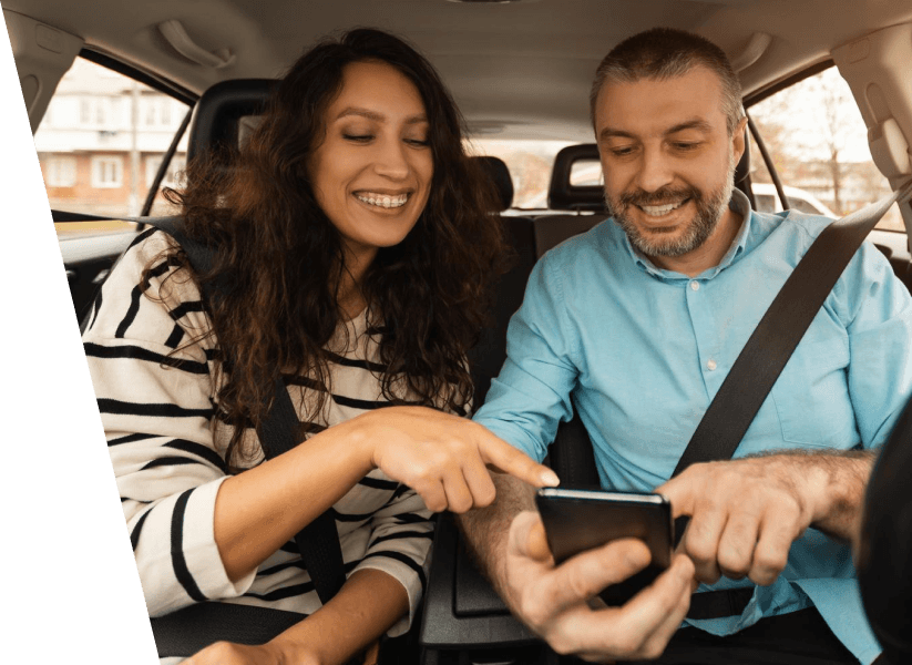 Casal no carro olhando para o celular