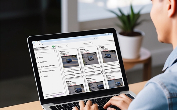 Pessoa ao computador com dashboard de gestão de ocorrências